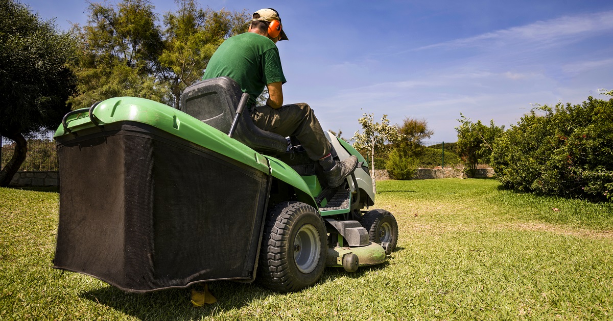 A man drives a lawn mower.