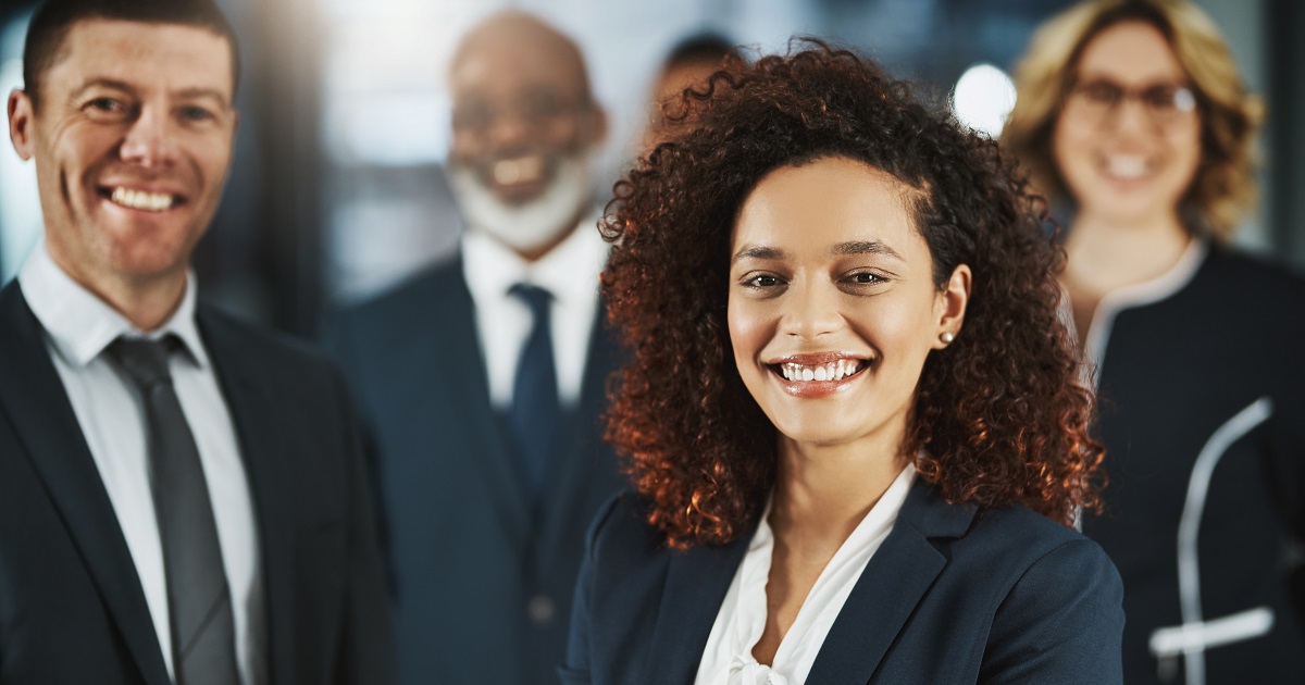 Group of smiling professionals look at camera