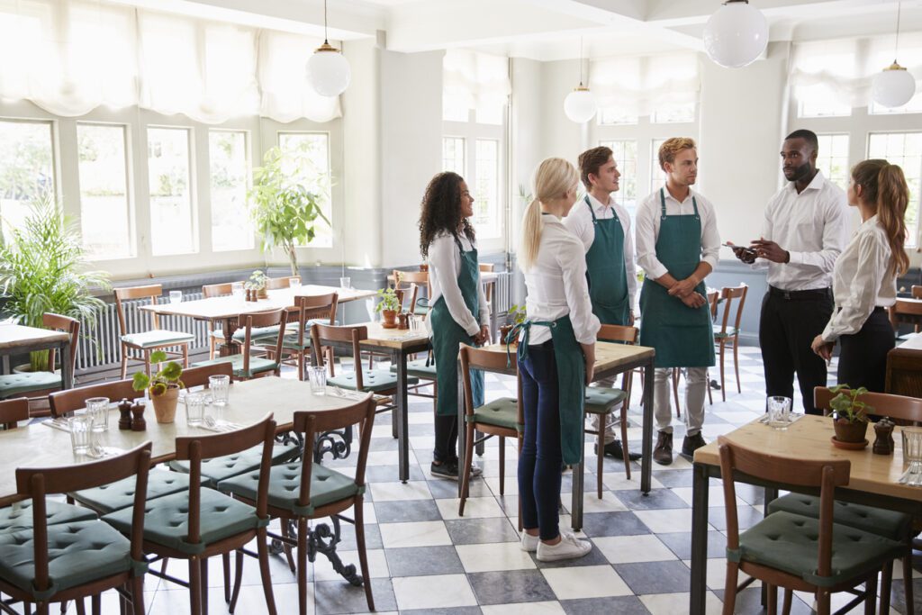 Staff Attending Team Meeting In Empty Dining Room