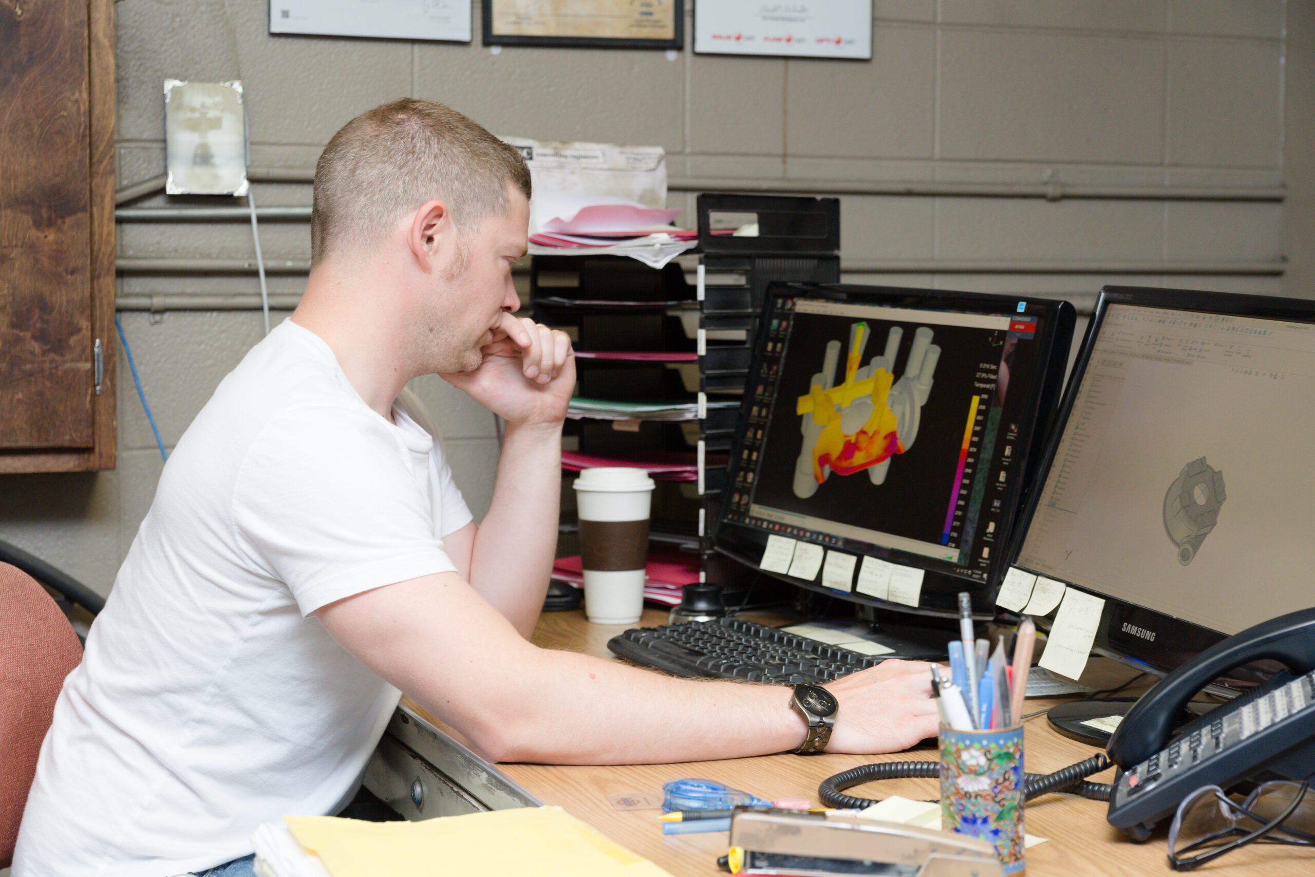 Employee sits at a computer work station preventing overexertion injuries