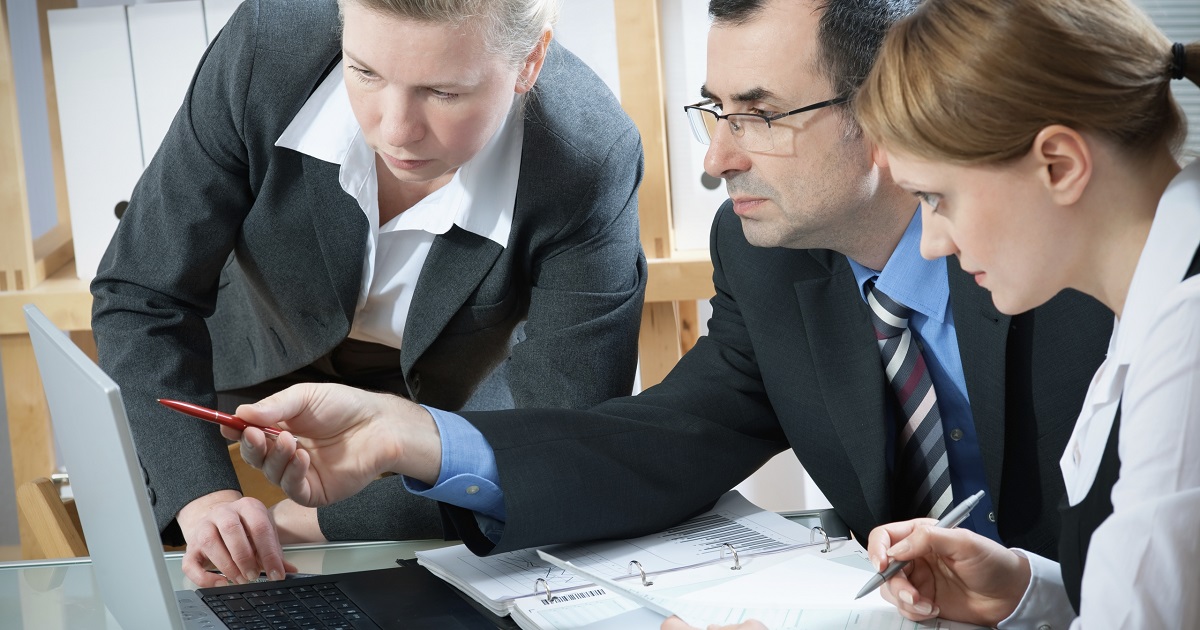 Group examines laptop screen