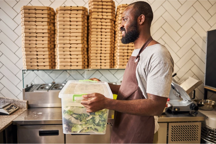 Restaurant worker carrying box of food